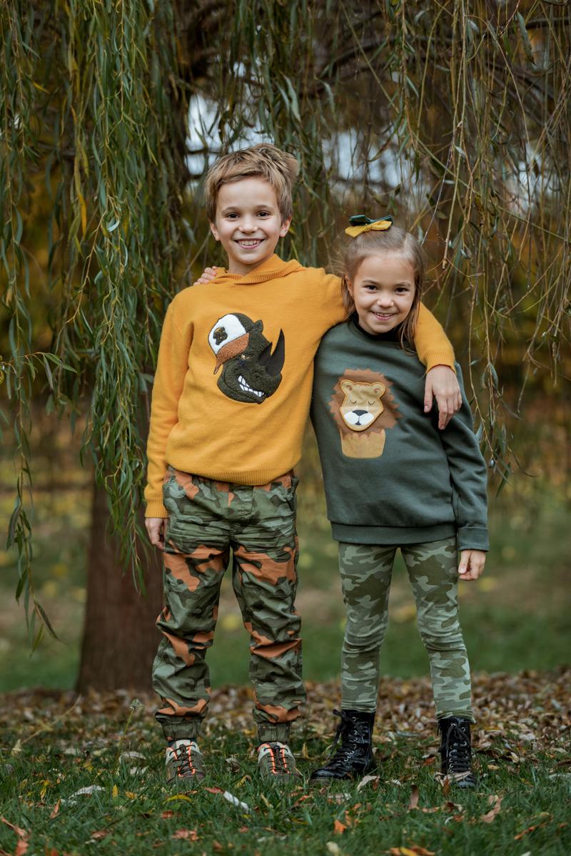 Due fratelli abbracciati nel bosco durante un servizio fotografico di famiglia