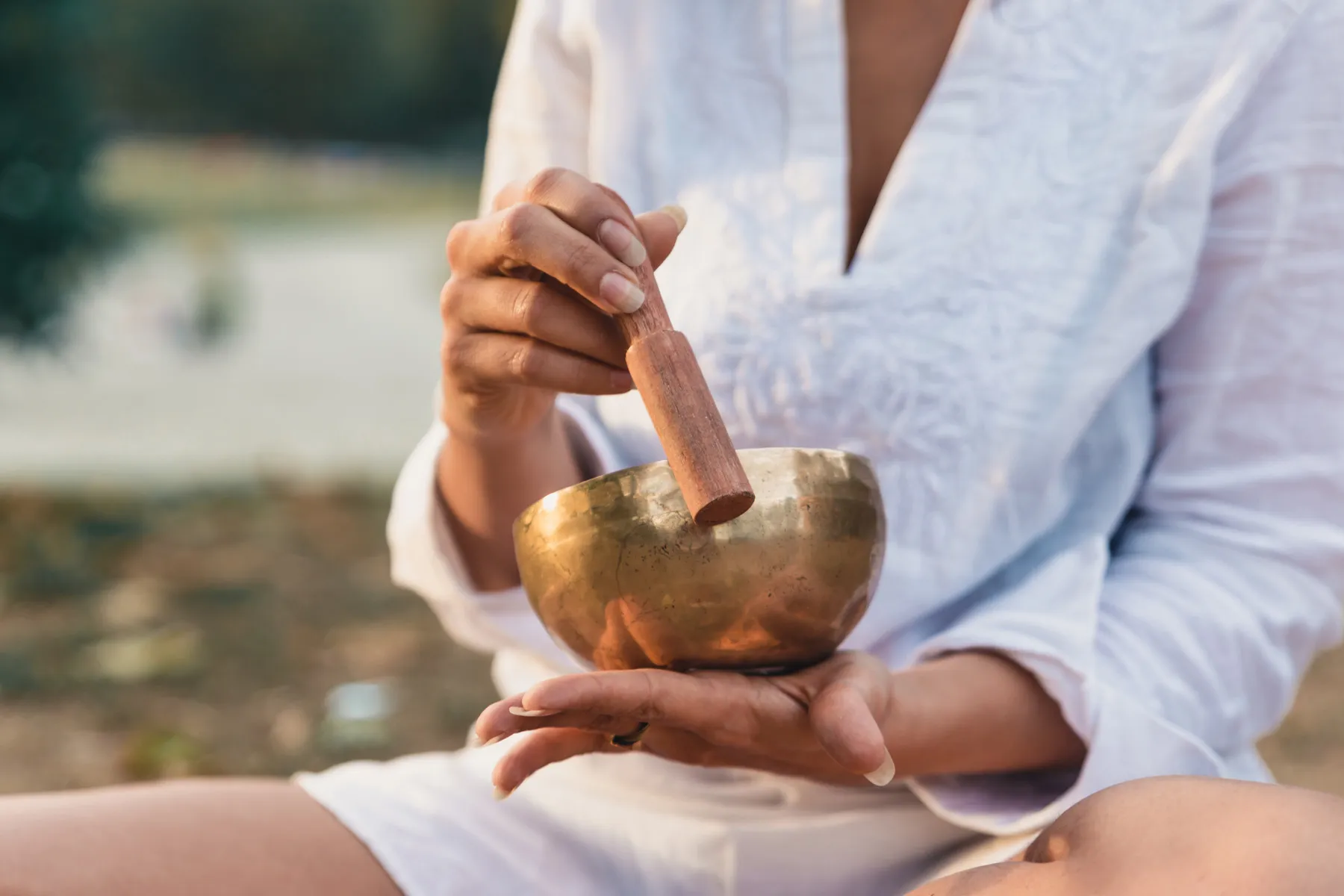 Mano che utilizza una campana tibetana durante una pratica di meditazione