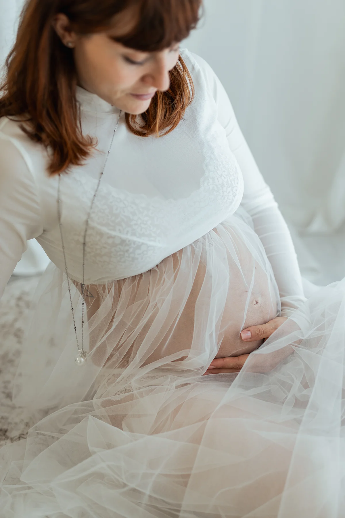 Dettaglio del pancione in gravidanza Dettaglio del pancione di una donna incinta avvolta in un abito bianco trasparente