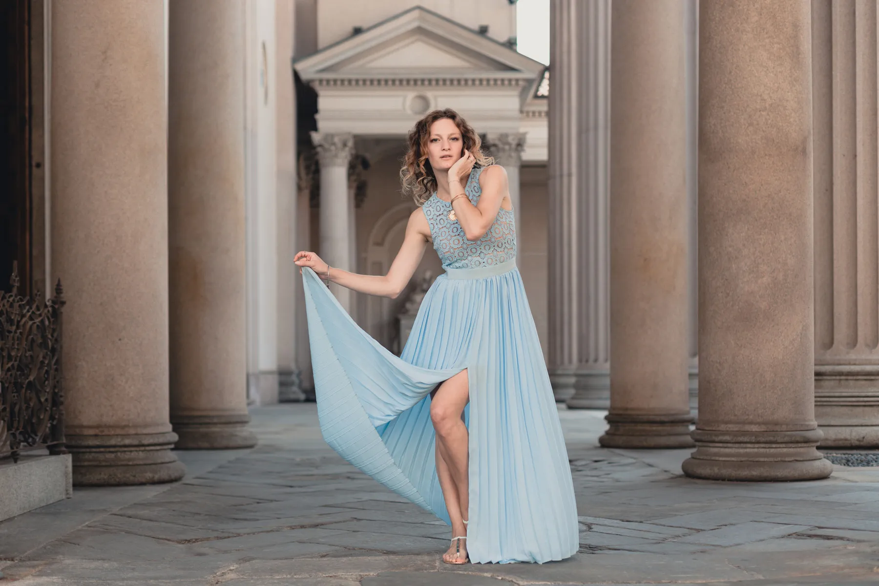 Editorial fashion con abito azzurro Modella con lungo abito azzurro fotografata tra le colonne di un edificio storico a Torino