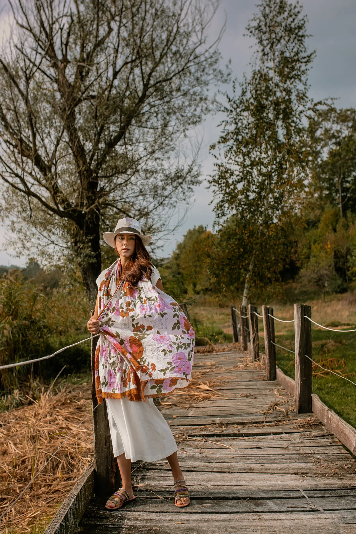 Fotografia fashion con outfit fantasia Modella con outfit fantasia fotografata su una passerella in legno nella natura