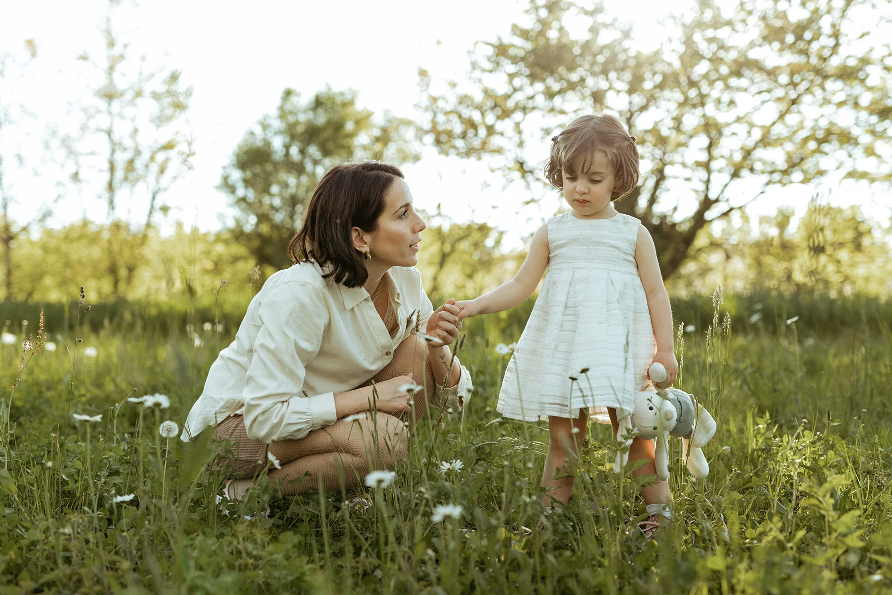 Mamma e bambina insieme in un prato durante un servizio fotografico di famiglia