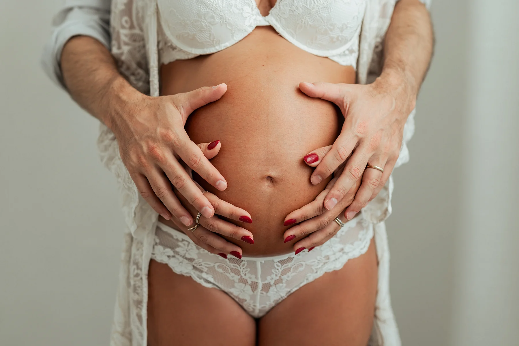 Mani sul pancione durante la gravidanza Dettaglio delle mani della futura mamma appoggiate sul pancione