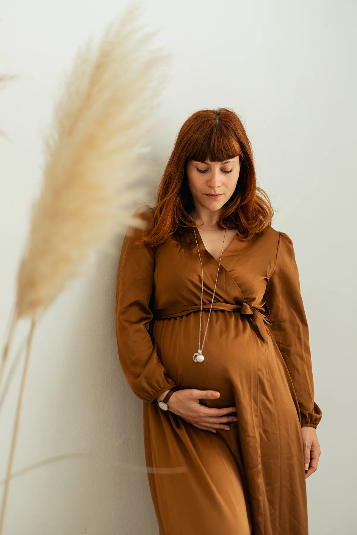 Ritratto maternity con abito marrone Donna in gravidanza con abito marrone e mano sul pancione