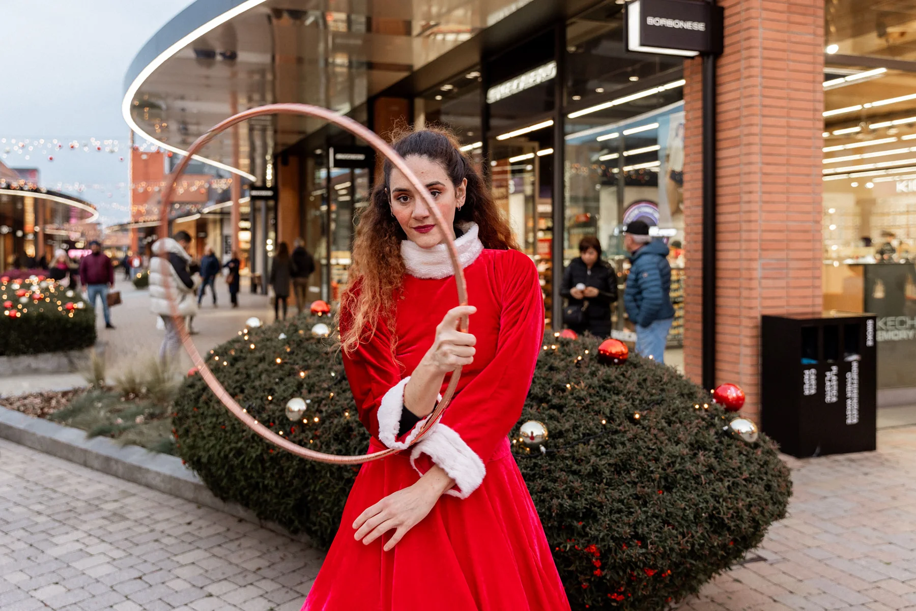 Performer in abito rosso con cerchio durante uno spettacolo all&rsquo;aperto