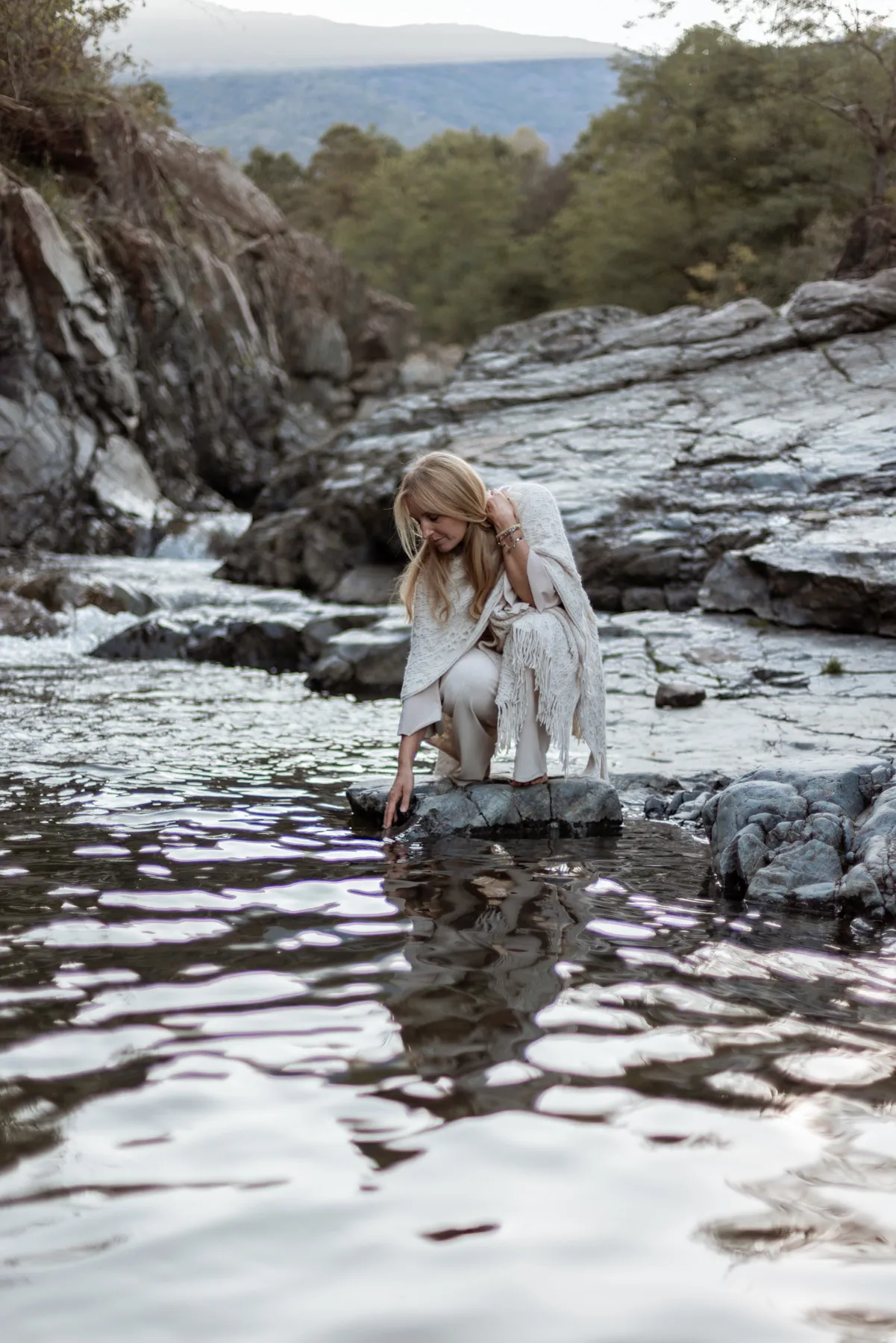 Donna immersa nell’acqua di un ruscello durante un servizio fotografico
