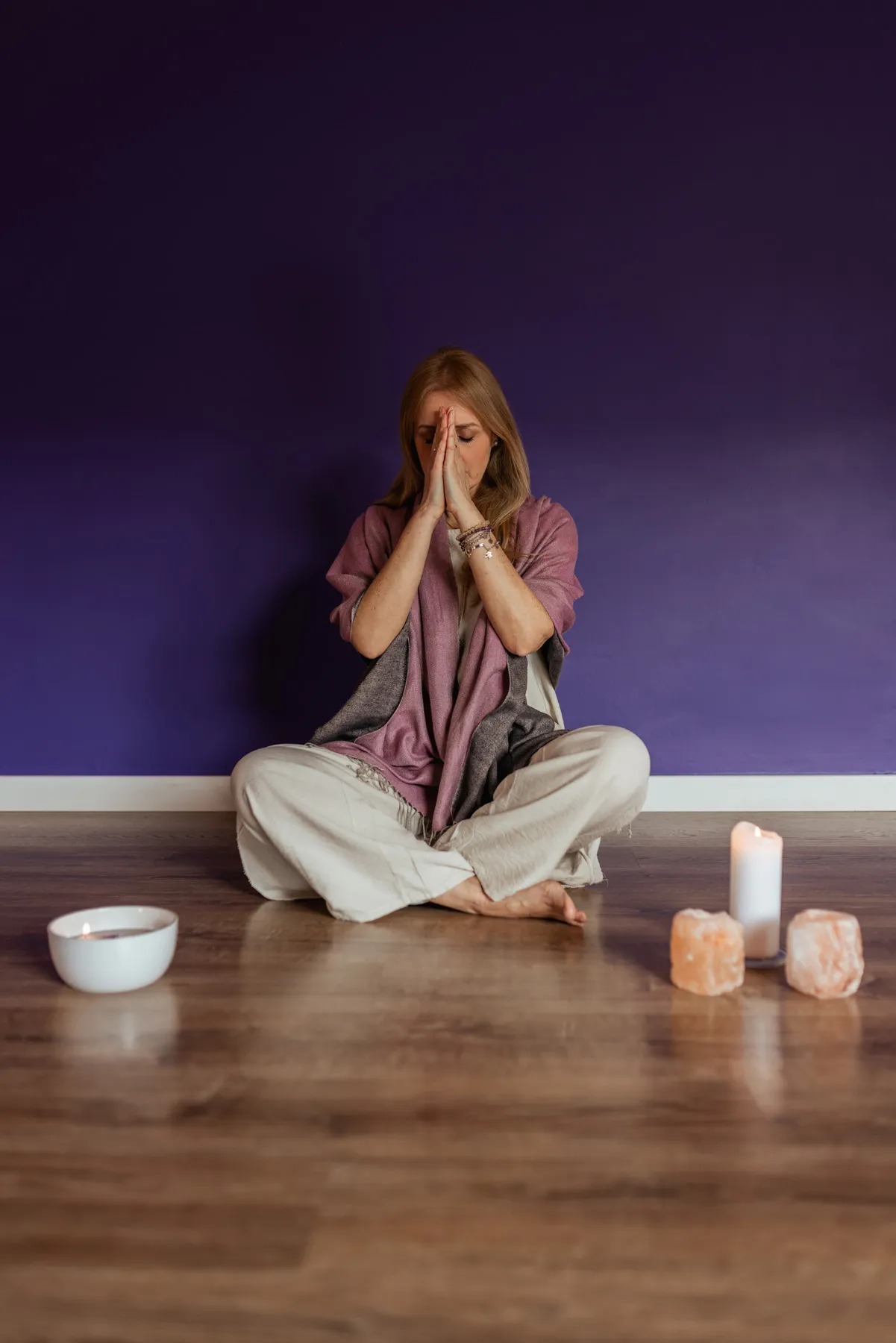 Donna con le mani raccolte davanti al viso durante una pratica di meditazione