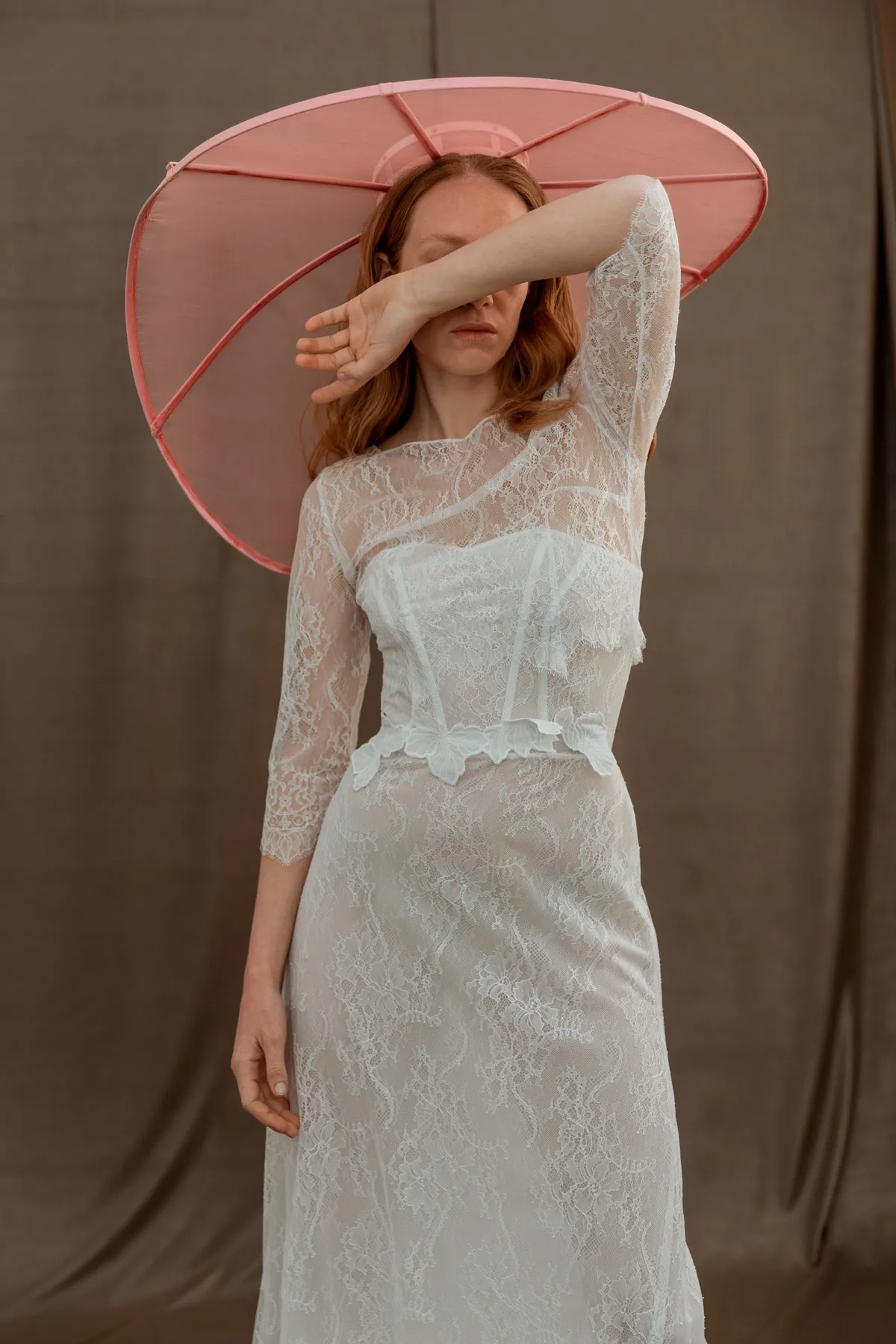 Shooting fashion sposa con cappello rosa Modella con abito da sposa in pizzo e grande cappello rosa durante uno shooting fashion