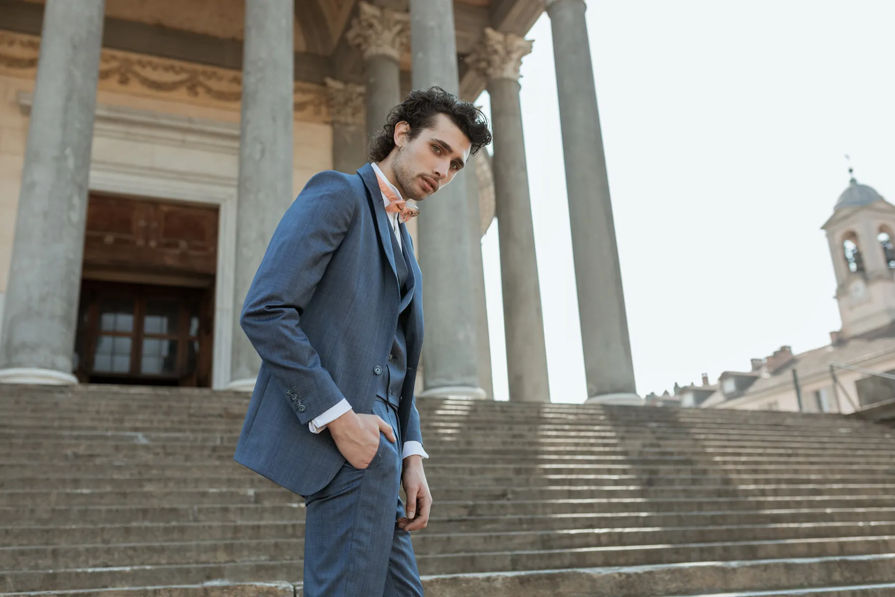 Shooting fashion uomo in abito blu Modello con abito blu fotografato all’aperto davanti a un edificio storico di Torino