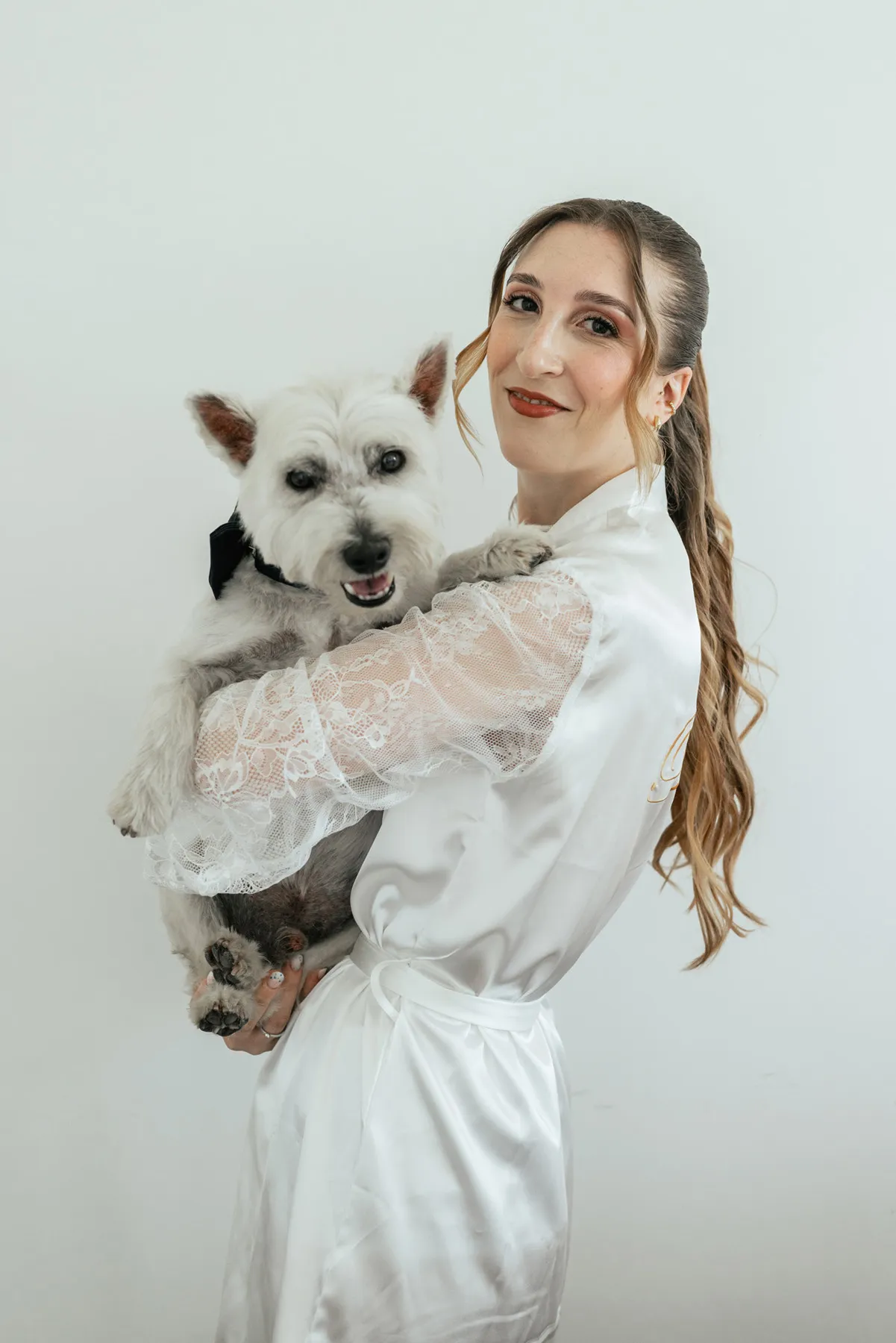 La sposa con il suo cane Sposa in vestaglia con il proprio cane in braccio