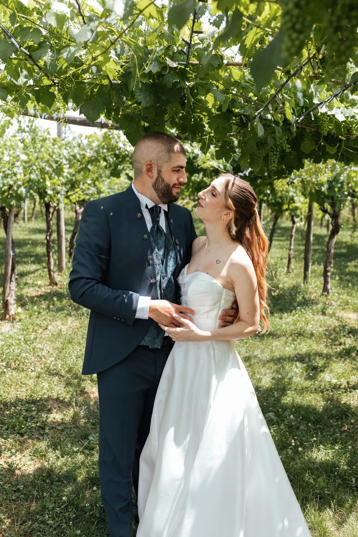 Gli sposi tra i vigneti Sposi abbracciati tra i filari di un vigneto