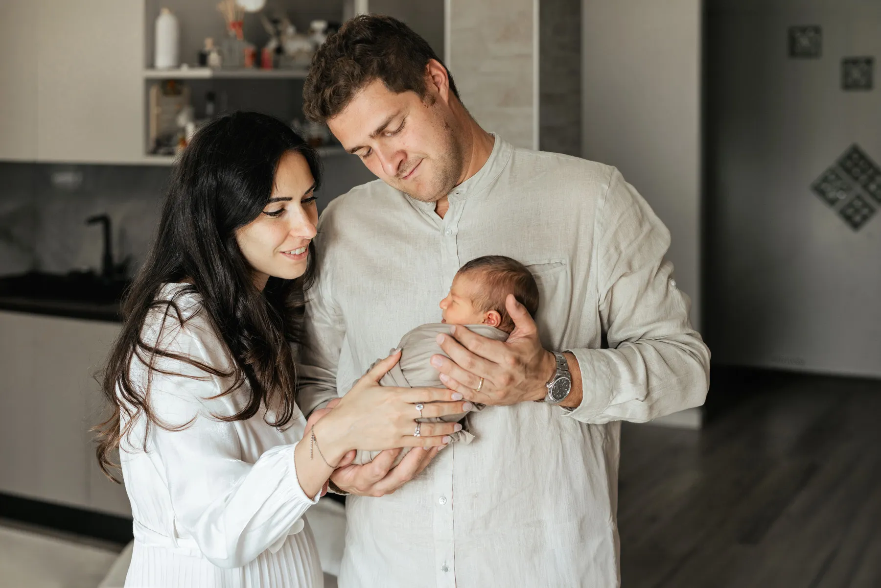 Mamma e papà con il loro neonato durante un servizio fotografico newborn a casa
