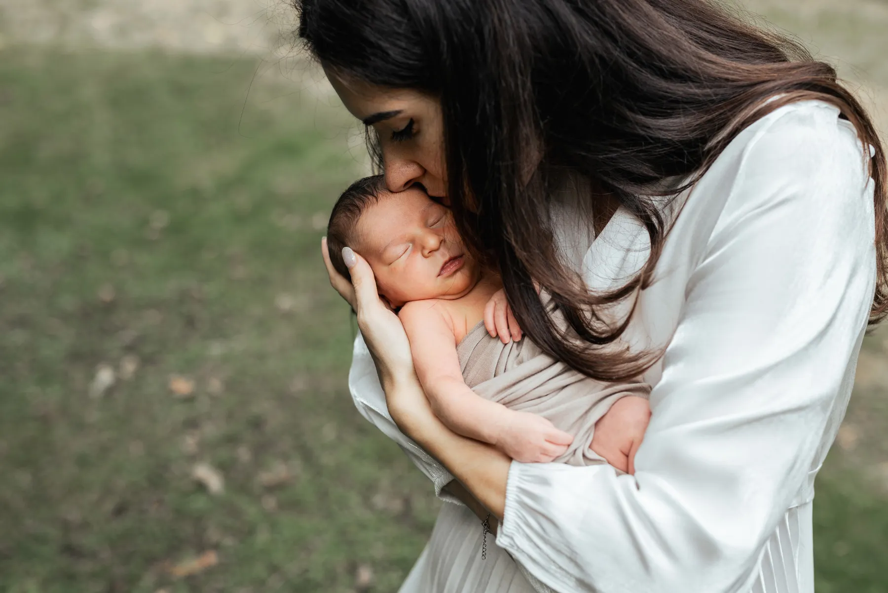 Mamma tiene in braccio il suo neonato durante una fotografia all'aperto